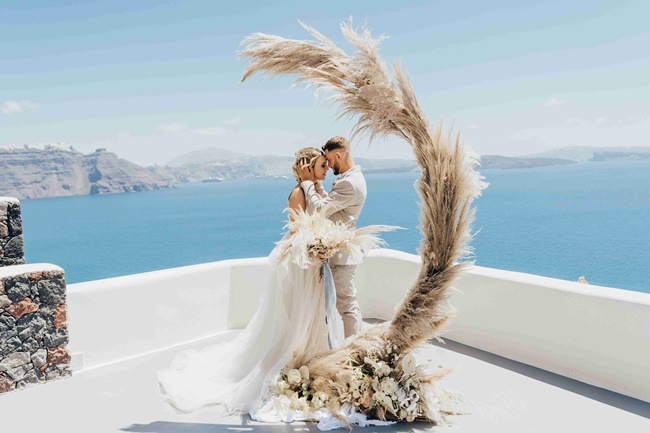 Modern and minimal ceremony arch with pampas grass in Santorini Greece